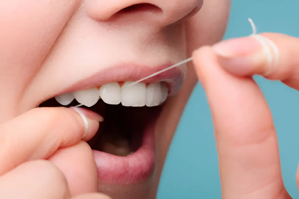 Person gently flossing teeth to reduce tooth pain