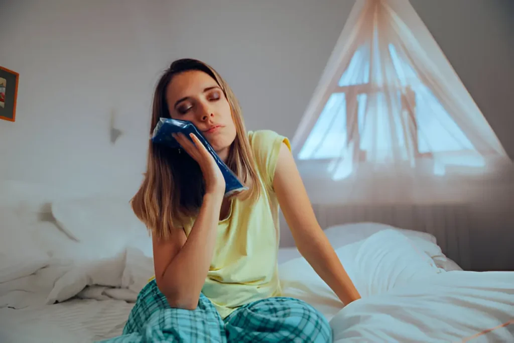 woman using a cold compress on cheek for toothache relief